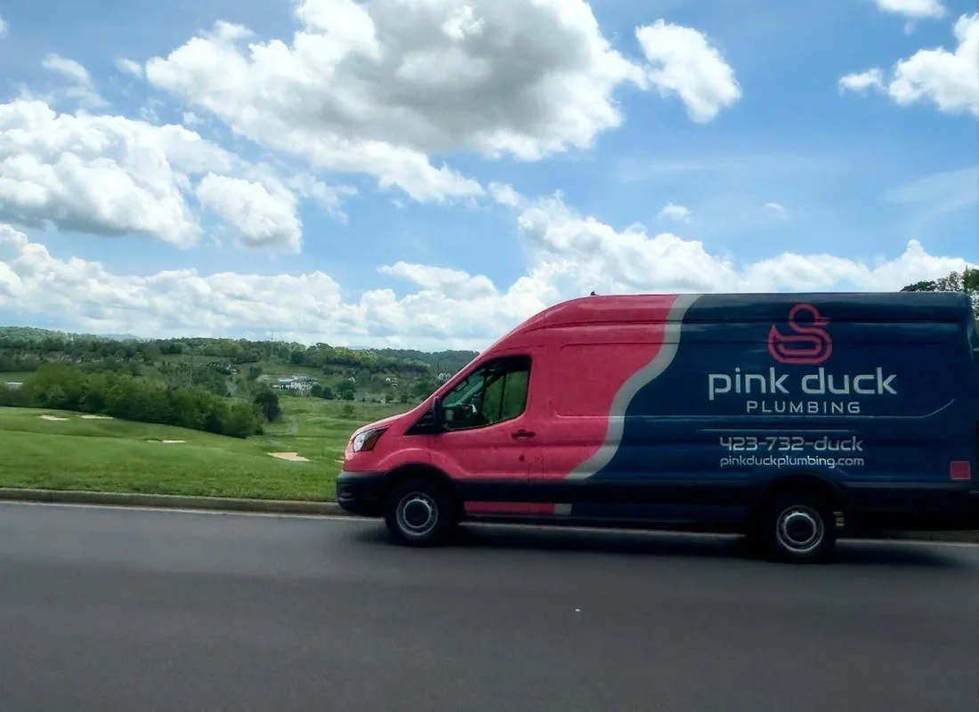 Pink Duck Plumbing technician repairing a leaking water heater in a Jonesborough, TN family home utility room