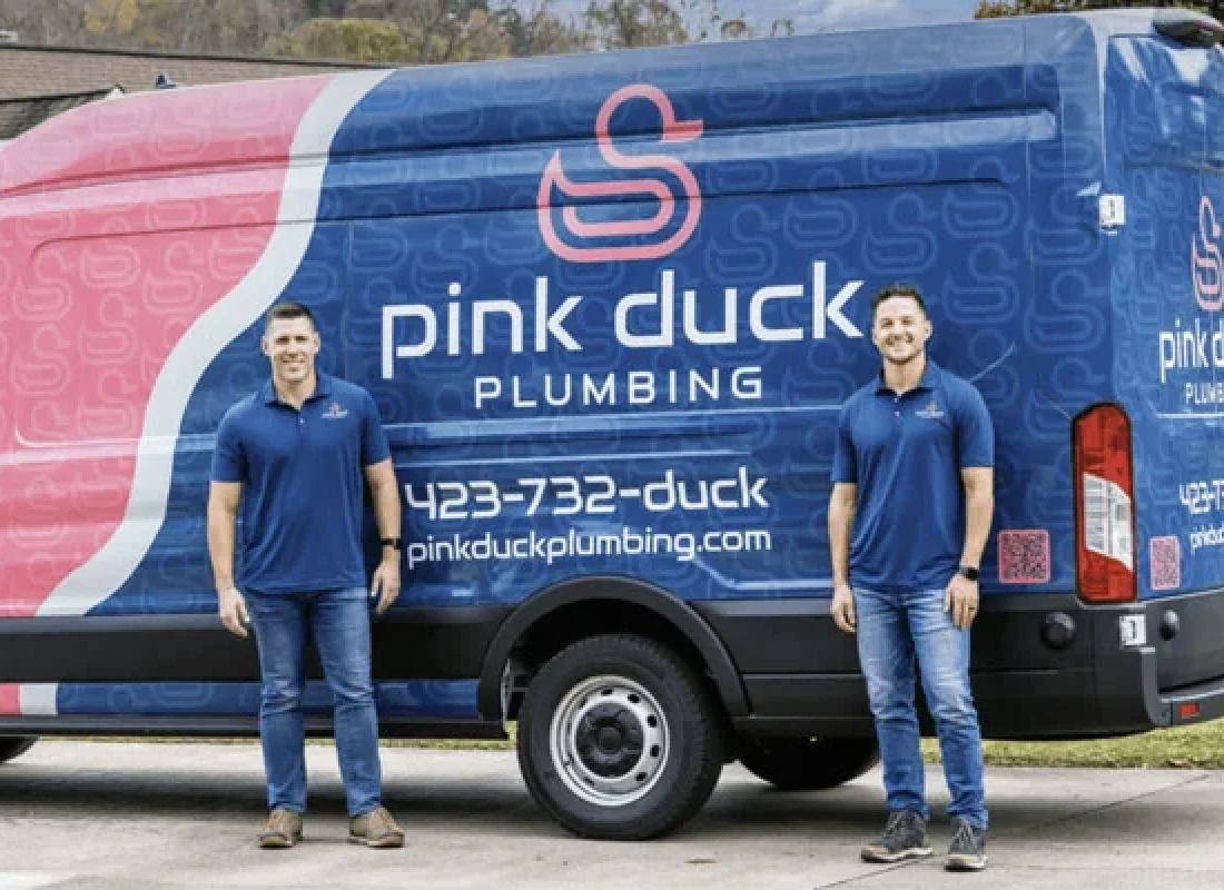 Licensed plumber from Pink Duck Plumbing repairing leaking pipe under kitchen sink in Fall Branch, TN home