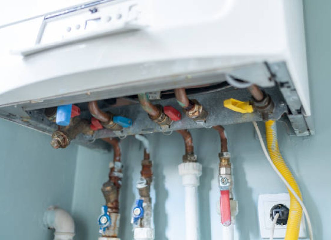 Plumber performing Water Heater Replacement beside a utility wall in Piney Flats, TN during a careful installation